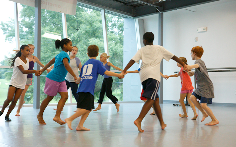 Kids holding hands and dancing in a circle