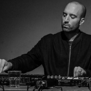 A black and white photo of Jake Meginsky working with sound equipment