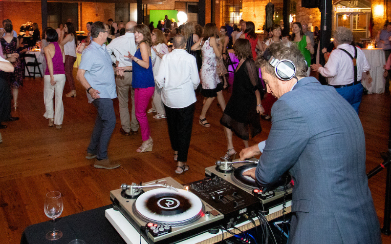 A dj playing for a crowd of dancing people