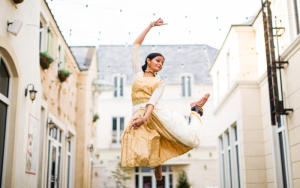 Ramya Kapadia jumping into the air outdoors surrounded by buildings